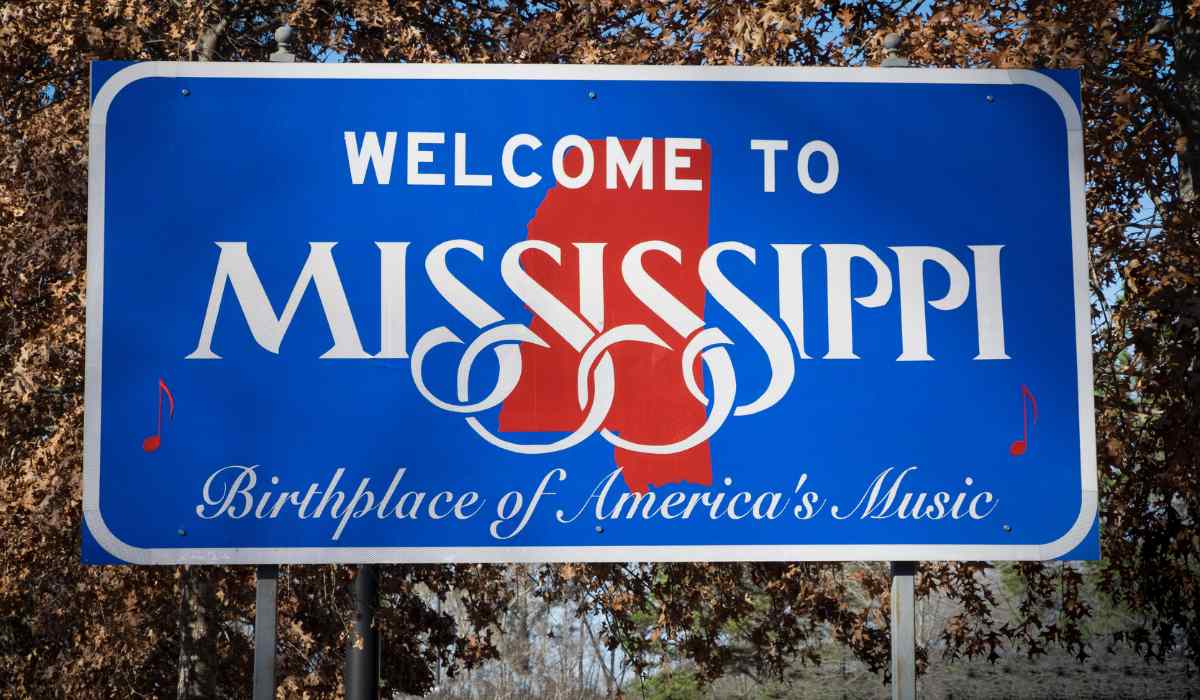 A close up of a Mississippi welcome sign on a street with "Birthplace of Americas Music" written on it. 