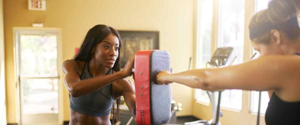 Two women in their home gym boxing.