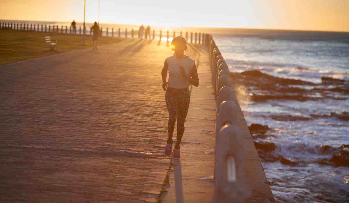 Woman on a run on a pier next to the ocean. 