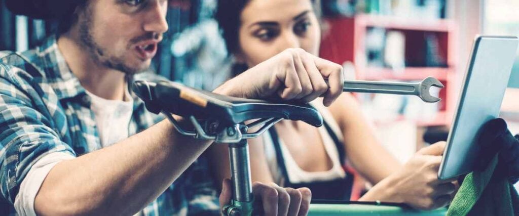 Two people looking at a bike in a bike shop. 