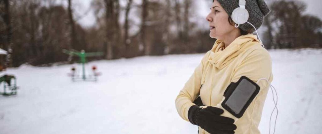 Woman trying to workout in the winter but looking for motivation on the side of the park. 