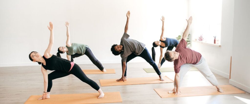 A group of people doing a yoga pose on mats.