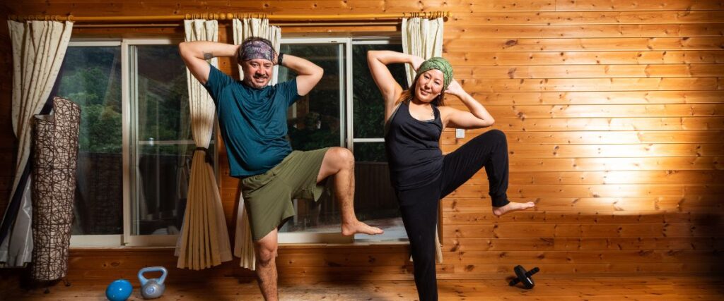 A couple working out in front of the computer having fun.