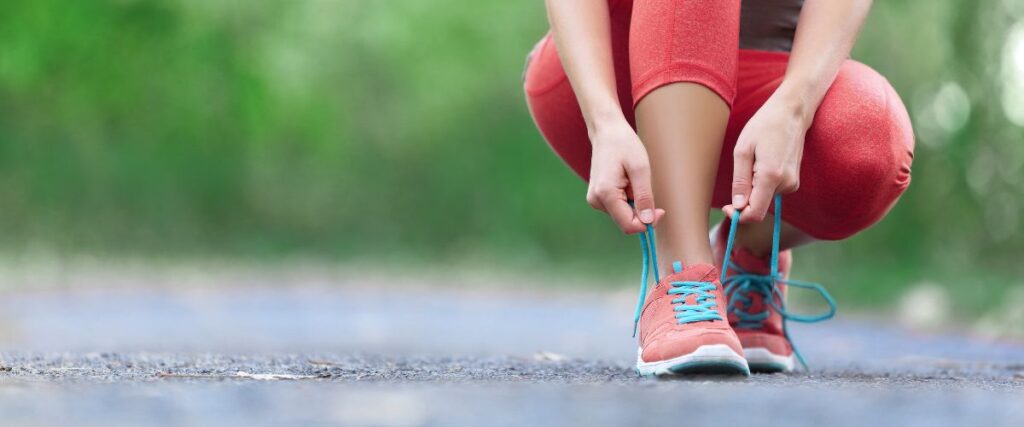 A female runner tying her shoes. 