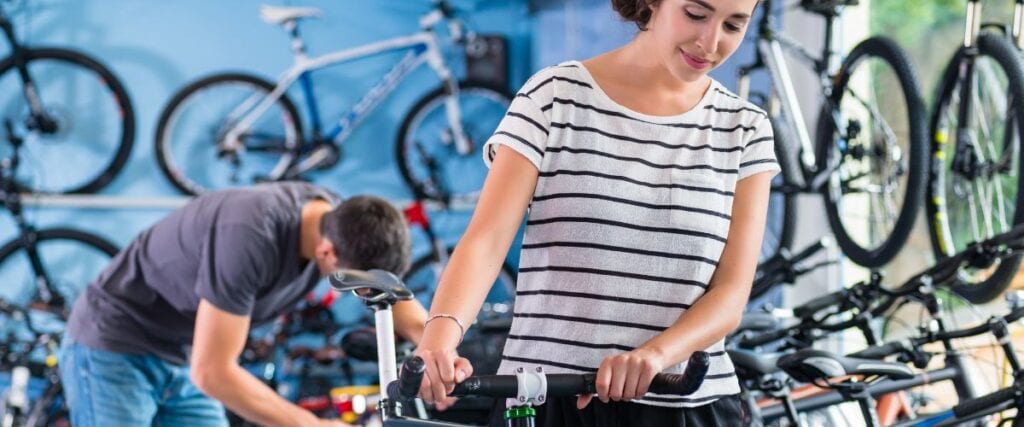 A woman getting her bike fitted at a bike shop. 