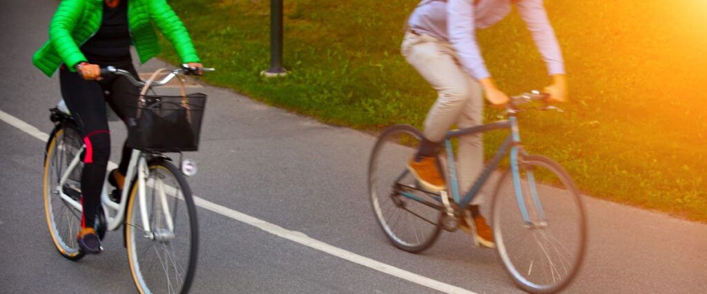 Two cyclists commuting to work on a bike path. 