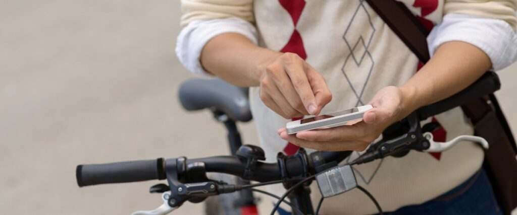 A man looking at his phone for his biking route to work.