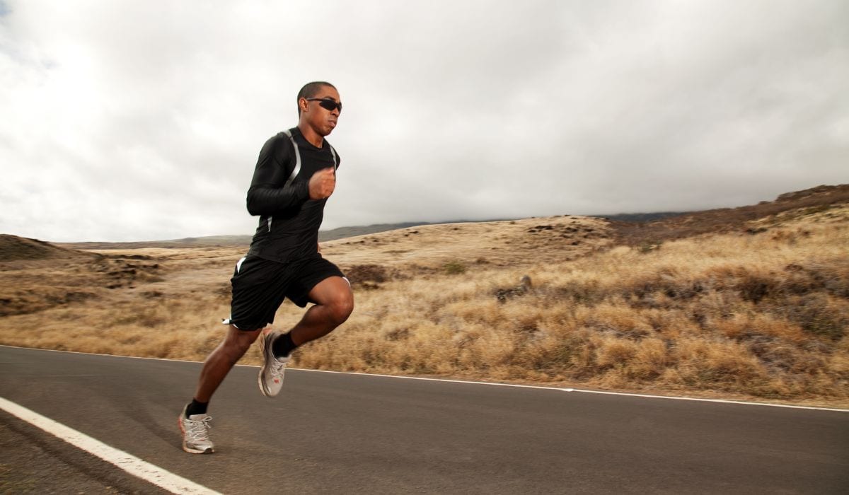 Male runner on road doing speed training. 