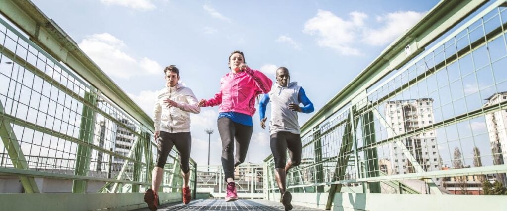 A group of runners going over a bridge together mid-run.