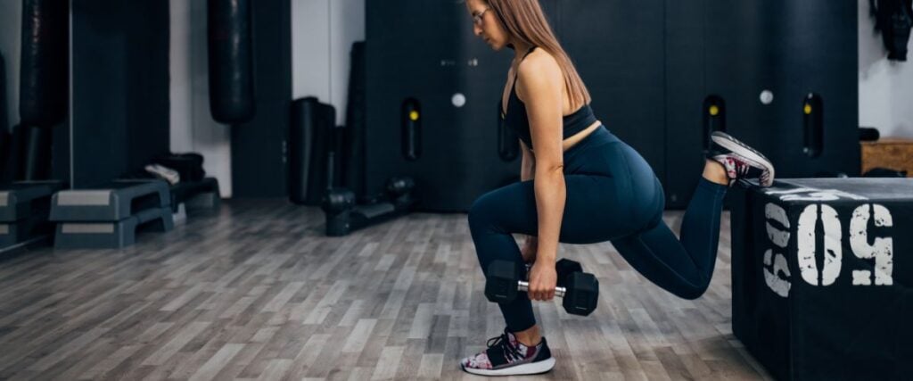 A woman doing a Bulgarian squat at the gym. 