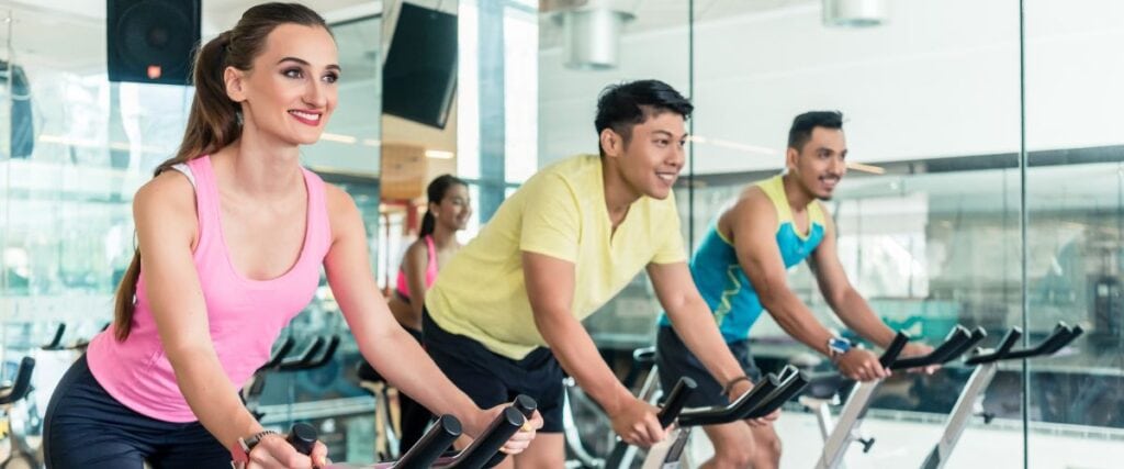 A group of people at a cycling class at the gym. 