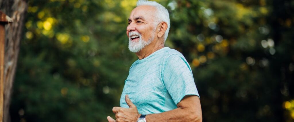 An older man running while smiling. 