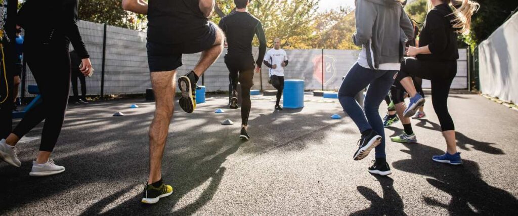 A group of people do an aerobic exercise together: jogging.