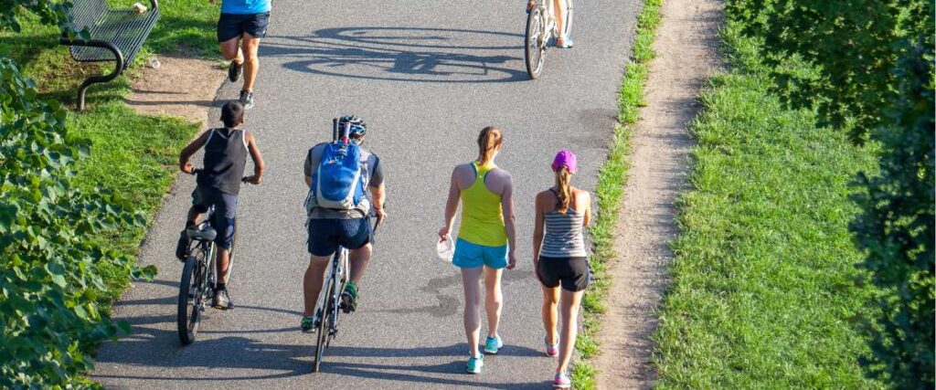 A group of people cycle and run together.